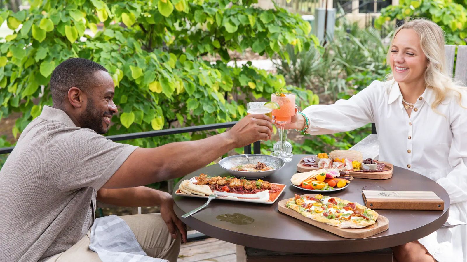 A couple sharing flatbreads and drinks on the terrace