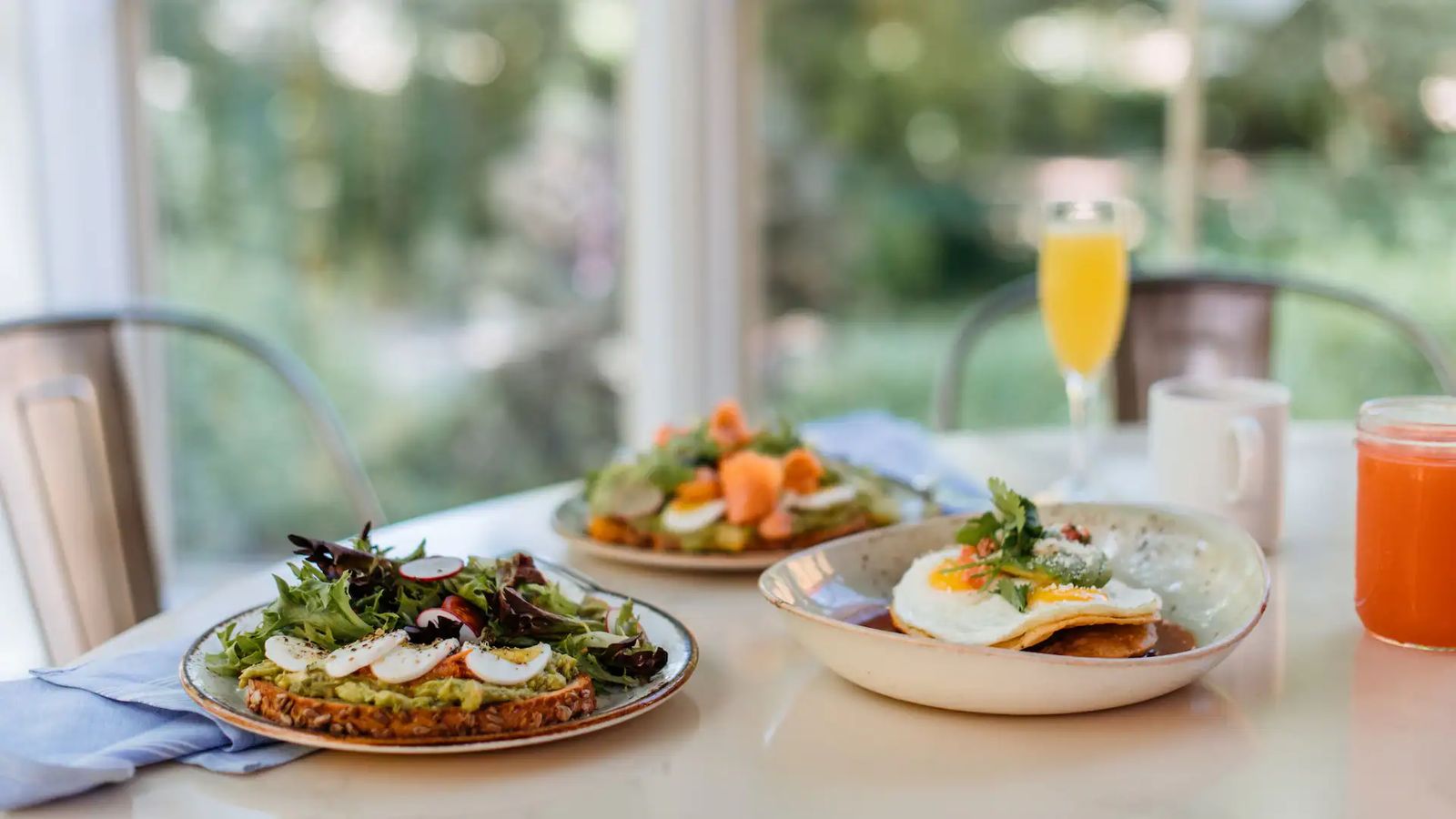 Breakfast plates and juice on a sunlit table